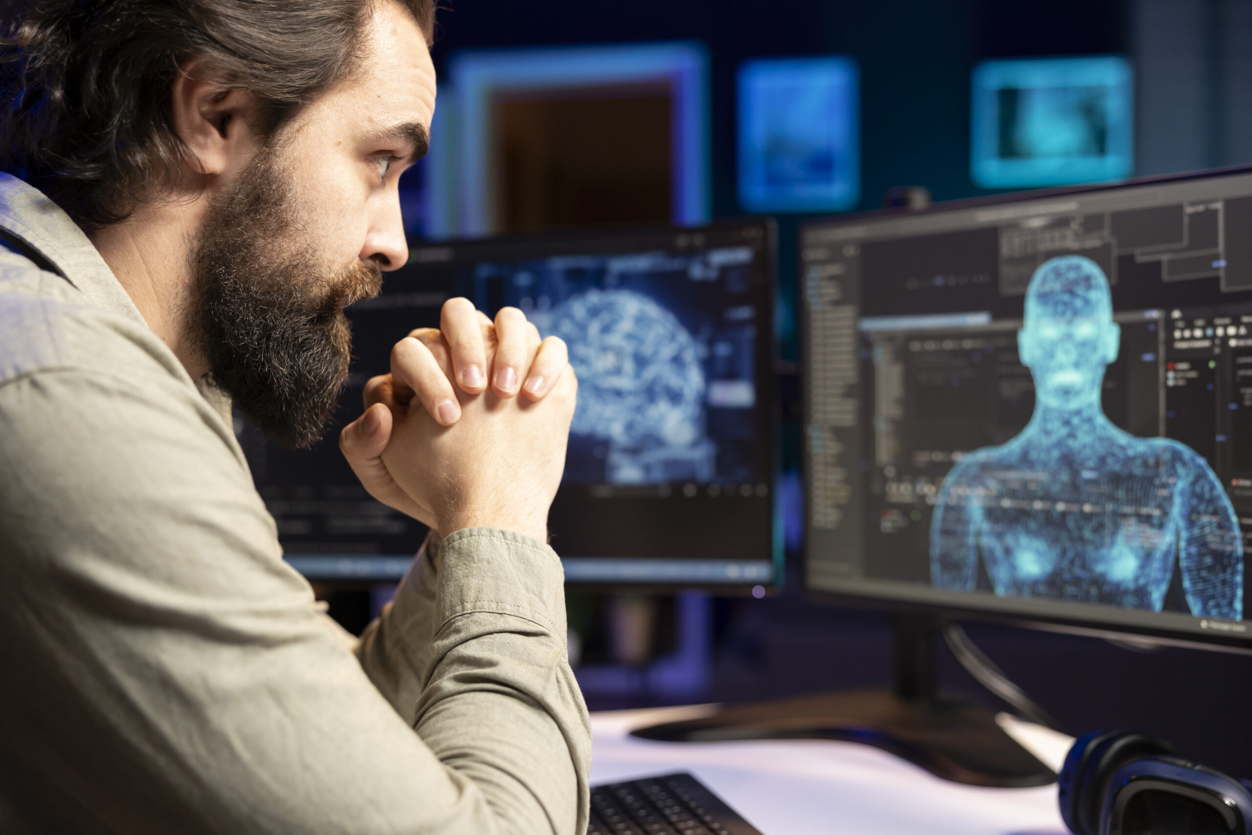 Homem observando telas de computador com visualização digital de corpo humano e gráficos de dados, representando análise tecnológica e inteligência artificial.