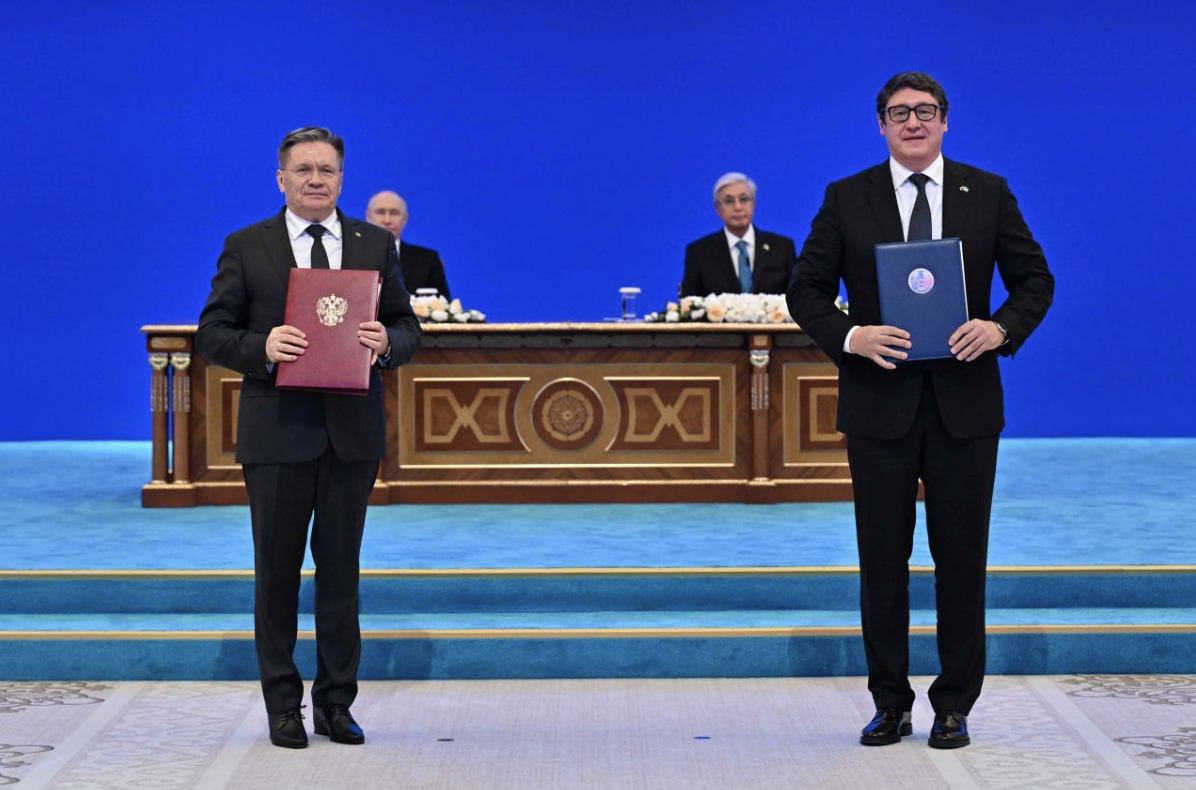 Dois representantes seguram pastas com documentos durante cerimônia oficial de assinatura do acordo para construção da Usina Nuclear de Balkhash, no Cazaquistão.