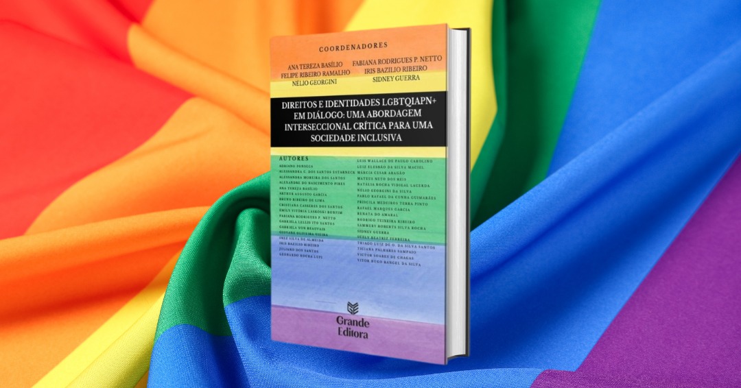 Livro “Direitos e Identidades LGBTQIAPN+ em Diálogo” aparece sobre uma bandeira colorida do orgulho LGBTQIAPN+