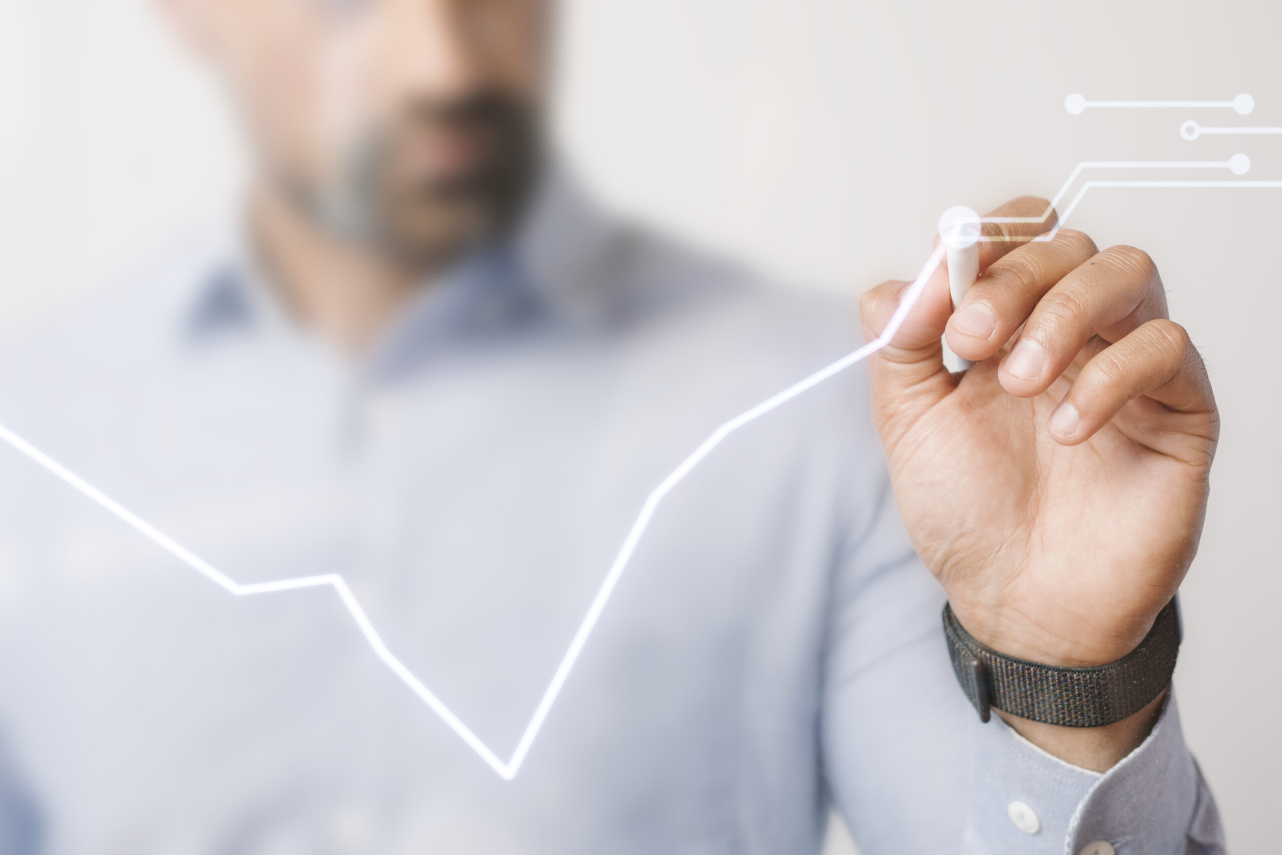 essoa desenha gráfico digital ascendente com caneta futurista, representando crescimento, análise de investimentos e tecnologia financeira
