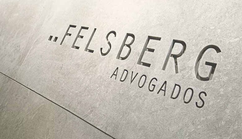Logotipo do escritório Felsberg Advogados aplicado em parede de acabamento claro, com destaque para o nome da banca